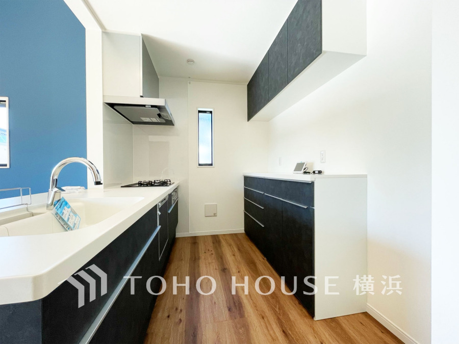 収納棚を背面に設置した統一感のあるキッチンスペースは美しく、機能性も良好です。
