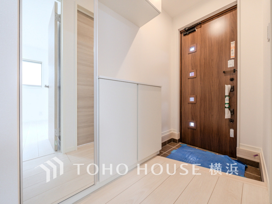 豊富な収納を確保した玄関スペース。便利な大型のミラーのついたシューズボックスを設置。