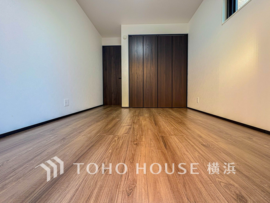 落ち着いた木目のフローリングと大容量収納を備えた、シンプルで使いやすい洋室空間です。