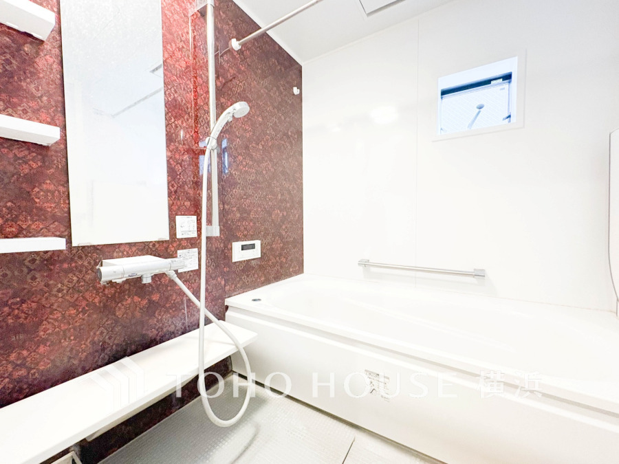 落ち着いたブラウンのアクセント壁が映えるバスルーム。小窓から自然光が差し込みます。