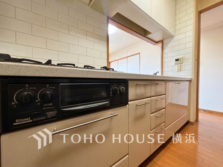 使いやすい収納と3口ガスコンロを備えた、機能的で清潔感のあるキッチン空間です。