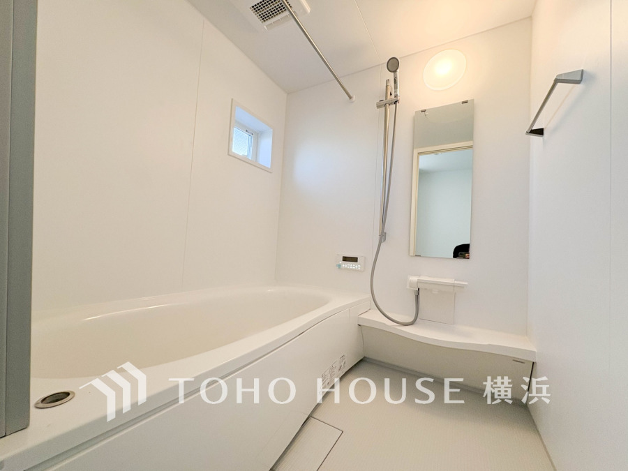 清潔感あふれる白を基調とした浴室。小窓から自然光が入り、快適なバスタイムを演出します。