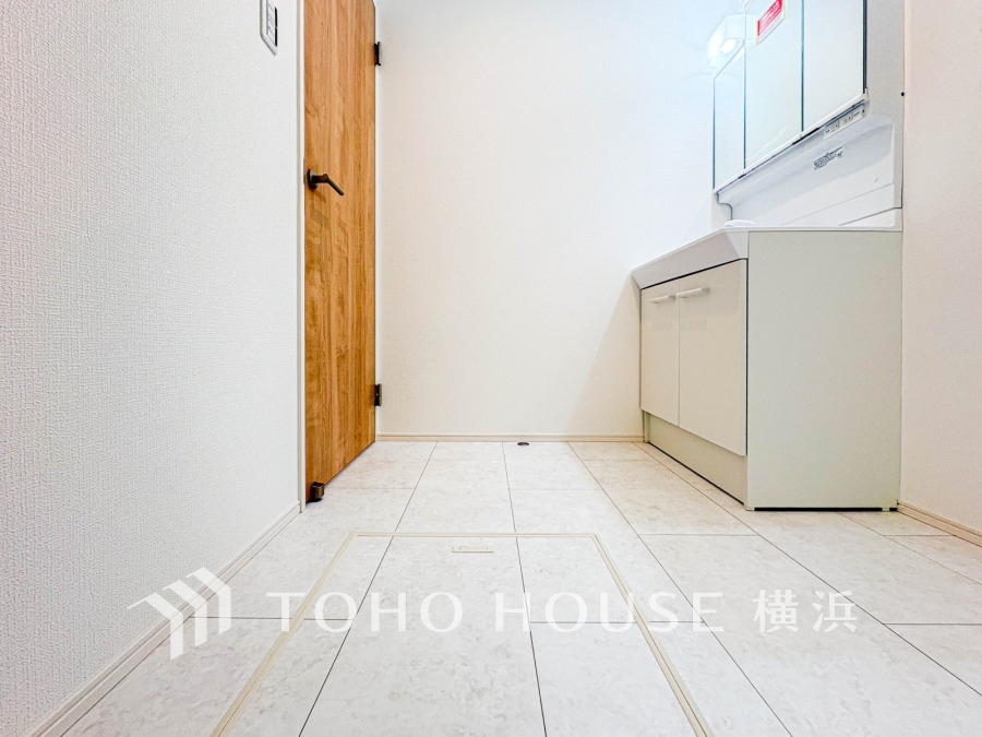 清潔感あふれる洗面スペース。広めの床スペースでゆったり使え、収納も充実した快適な設計です。