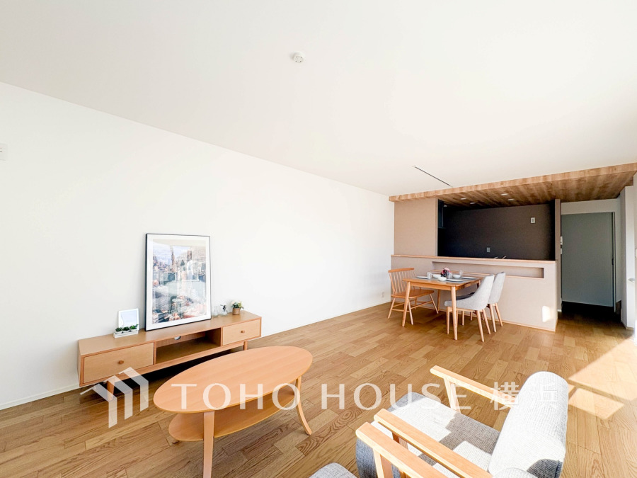 自然光が入り明るいリビングダイニング。木質の家具と床が温かみのある落ち着いた空間を演出しています。