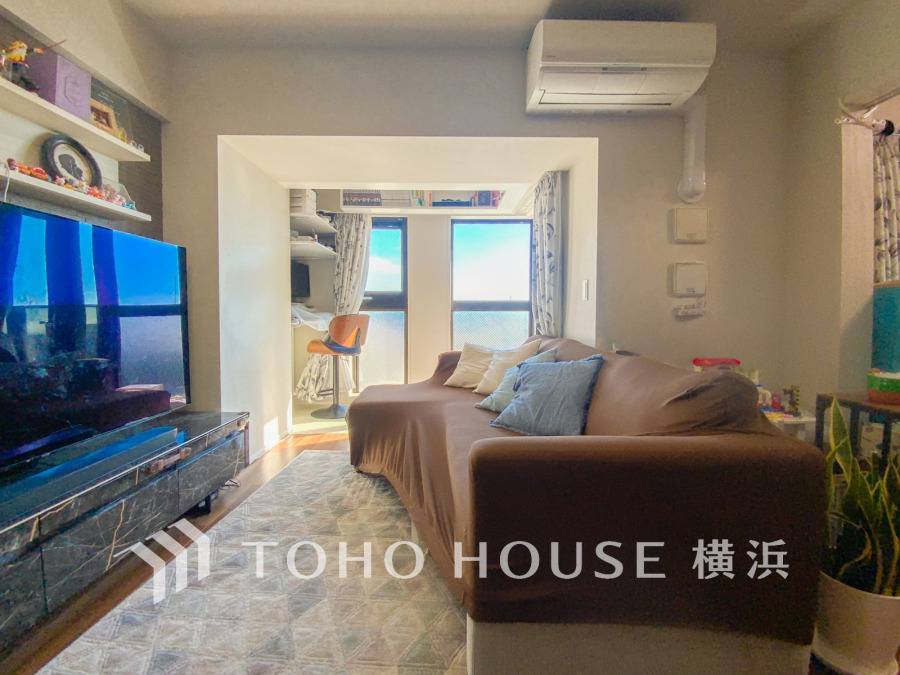 明るい窓から自然光が差し込む、落ち着いた雰囲気のリビングルーム。