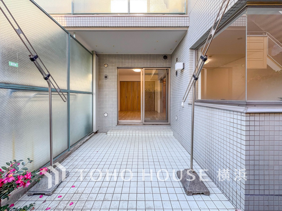 広々としたタイル張りのテラス付き1階住戸。室内とつながる開放感ある空間です。