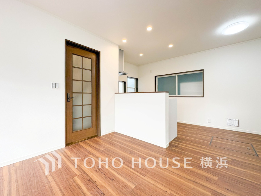 温かみのある木目調フローリングと白壁が調和した明るいリビング。使いやすい対面キッチンが魅力です。