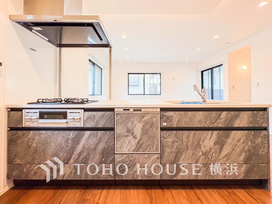 大理石調のデザインが美しい、機能的なシステムキッチン。広々とした空間で快適に調理が楽しめます。