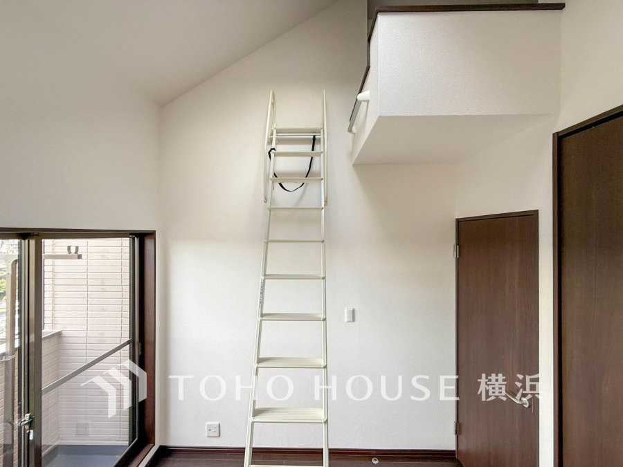 ロフトへ続くはしご付きのシンプルな洋室。大きな窓から自然光が入り、開放感のある空間です。