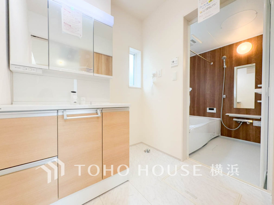 清潔感ある洗面台と木目調の落ち着いたバスルームが調和した、機能的で快適な水回り空間です。