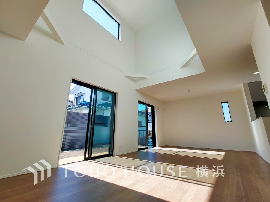 大きな窓から光が降り注ぐ開放的なリビング。吹き抜け天井が空間に広がりを与えます。