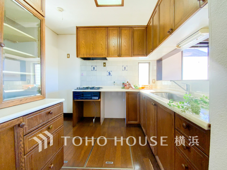 木目調の温かみあるキッチンは収納豊富で使い勝手良く、自然光が差し込み明るい空間を演出します。