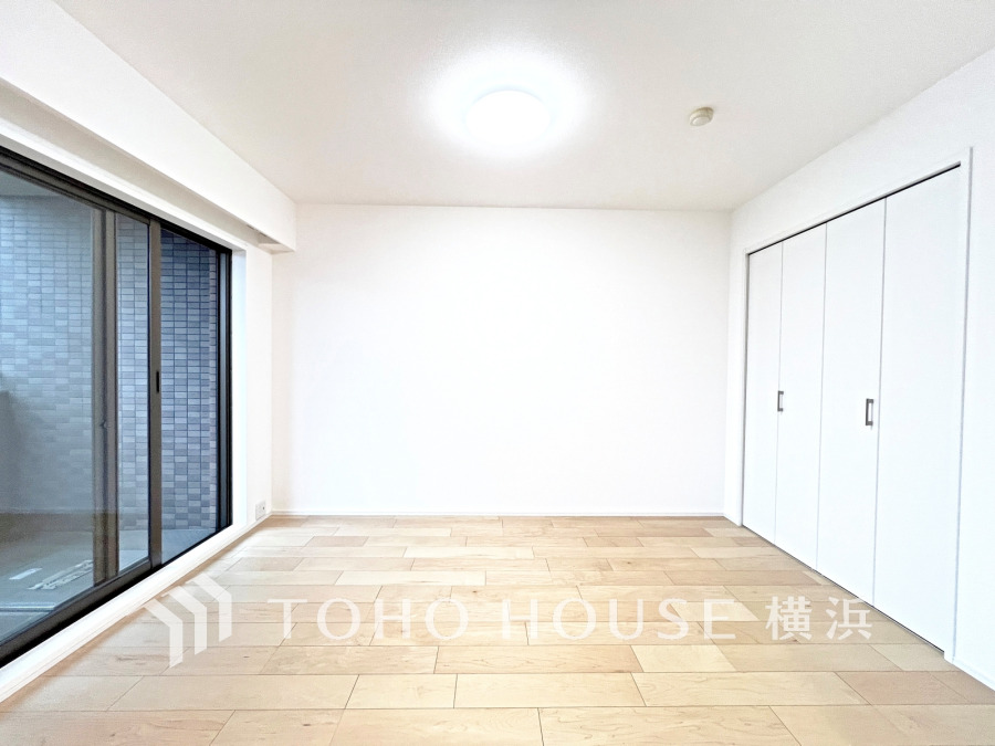 バルコニーから明るい自然光が差し込む洋室。大型クローゼット付きで収納も充実しています。
