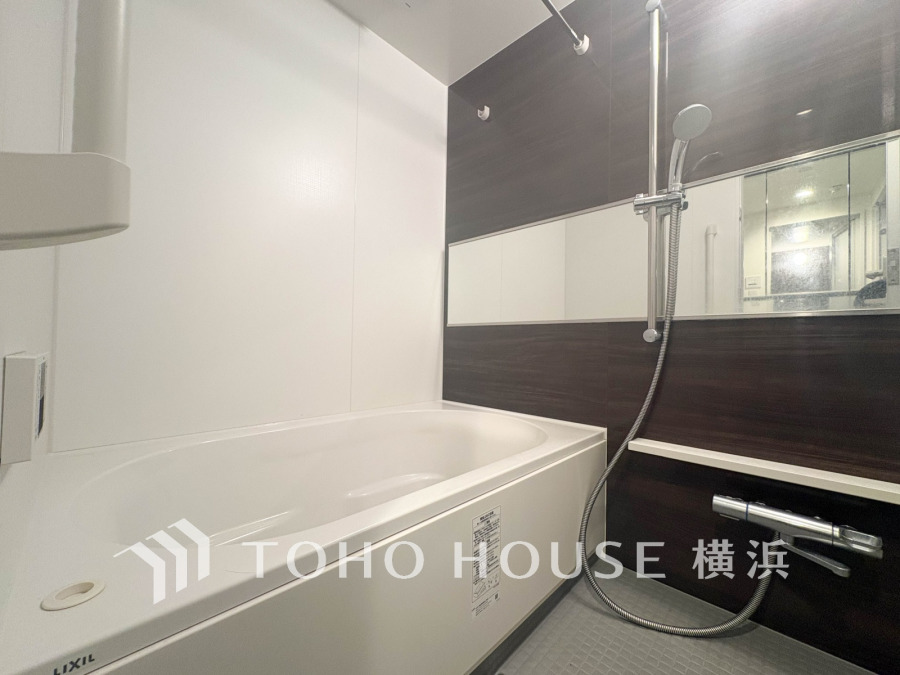 落ち着いたダークパネルと清潔感あるホワイトが調和した、ゆったり寛げるバスルームです。