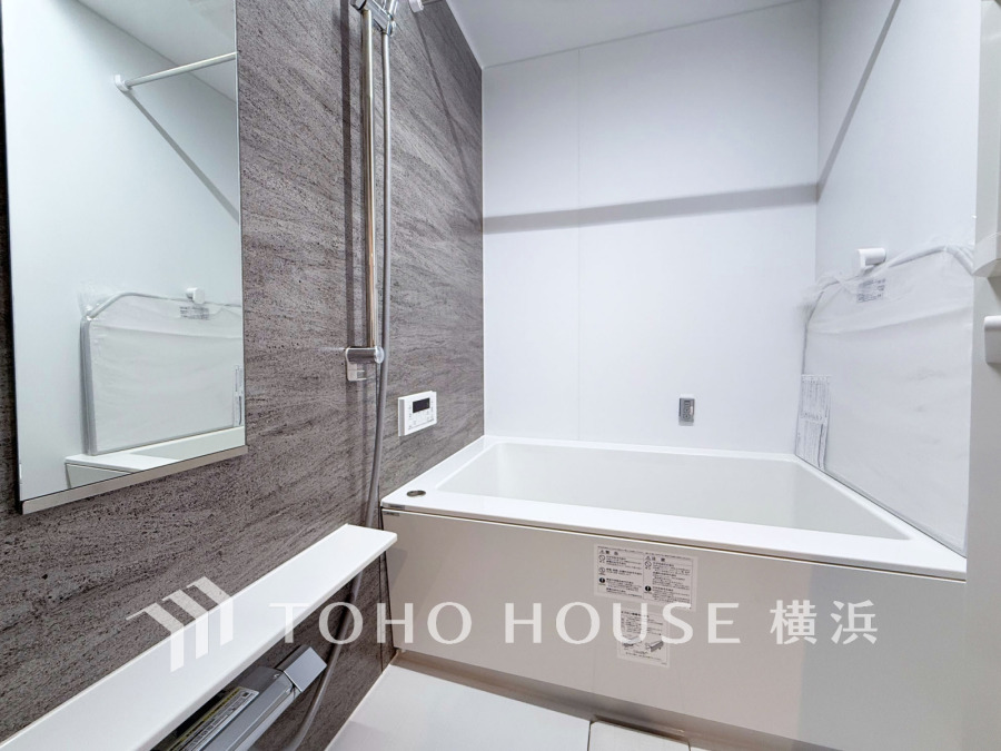 落ち着いたトーンの壁面と清潔感のあるホワイトが調和した、機能的で快適なバスルームです。