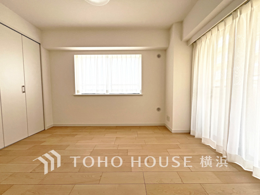 バルコニーから明るい自然光が差し込む洋室。大型クローゼット付きで収納も充実しています。
