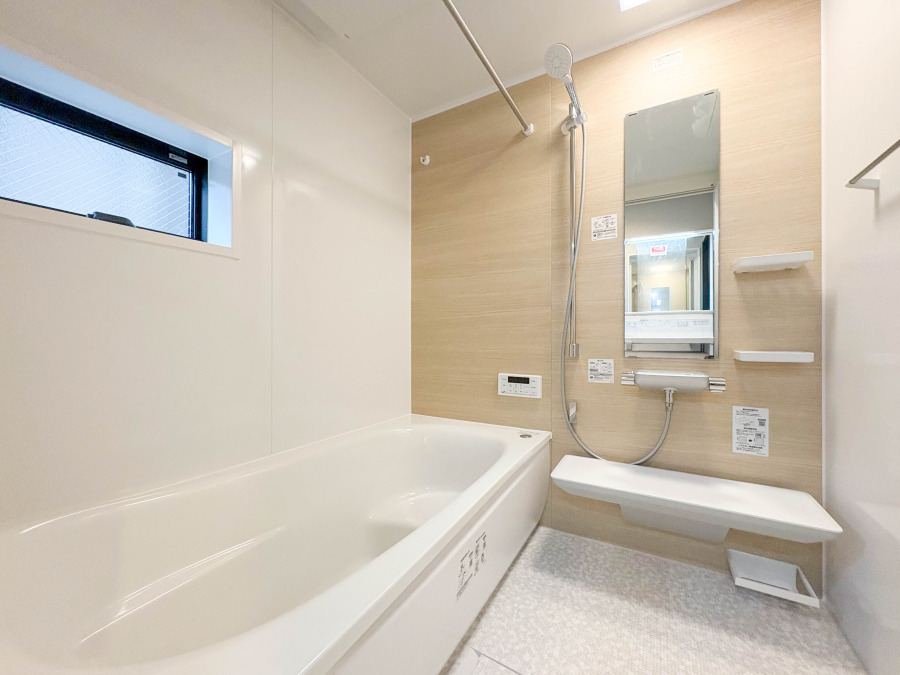 清潔感あふれる明るいバスルーム。ウッド調の壁面が温かみを演出し、ゆったりくつろげる空間です。