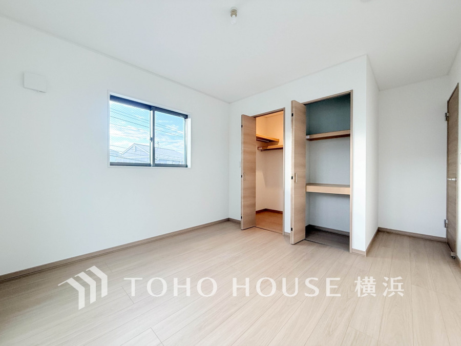 明るい自然光が差し込む、収納充実のシンプルな洋室。快適な住空間を実現します。