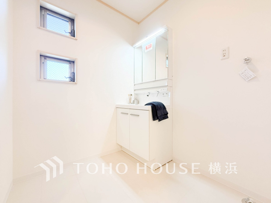 清潔感あふれる白を基調とした洗面室。小窓から自然光が入り、明るく快適な空間を演出します。