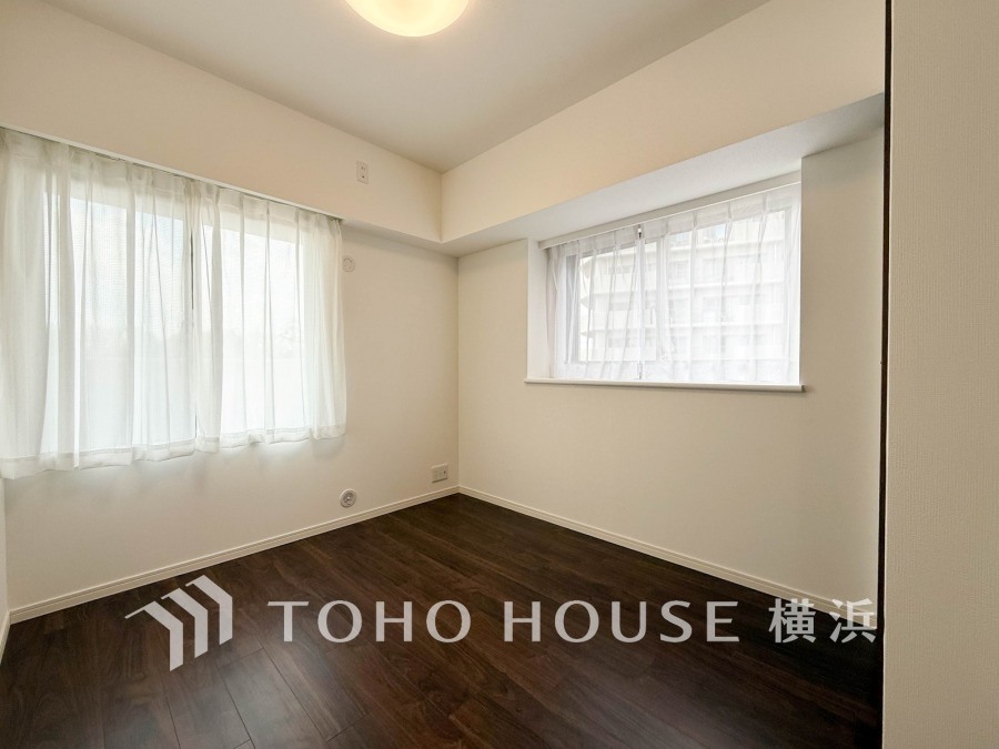 二面採光で明るく風通しの良い洋室。落ち着いたダークブラウンのフローリングが上質な空間を演出します。