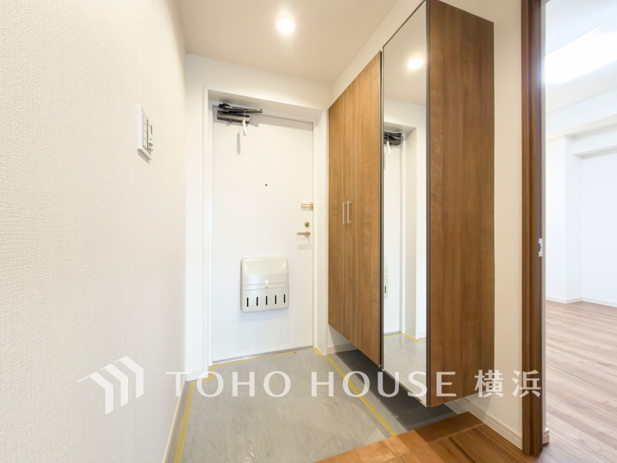 清潔感あふれる白を基調とした玄関。大容量の鏡付きシューズボックスで収納力と利便性を両立しています。