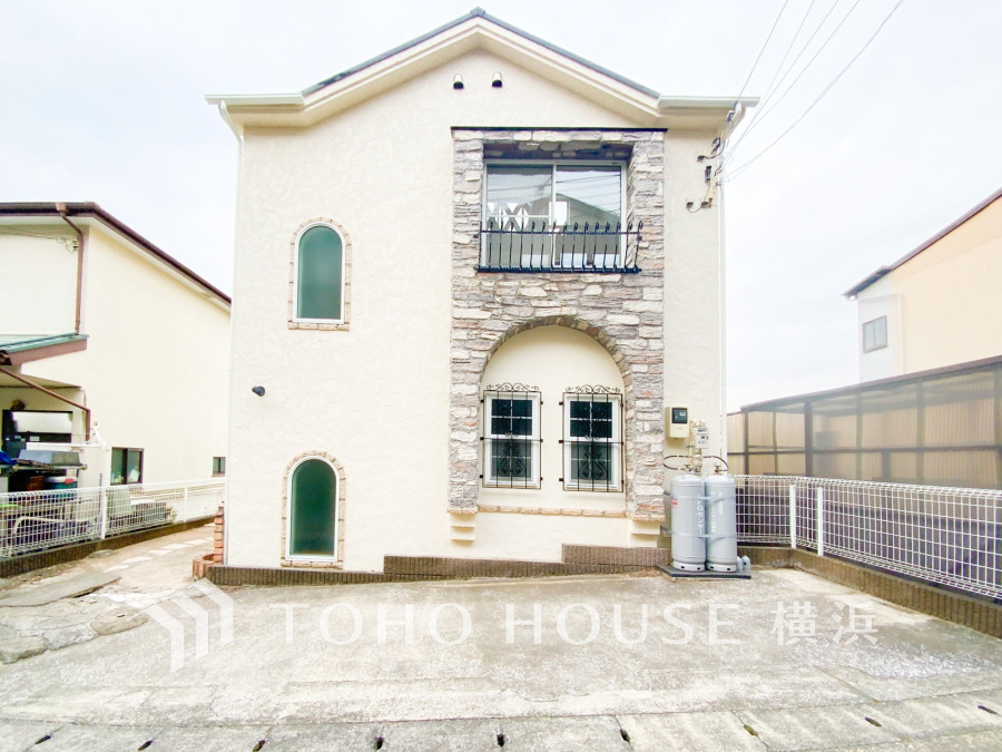 石造りとアーチ窓が特徴の洋風デザイン。開放感ある駐車スペース付きの明るい外観です。