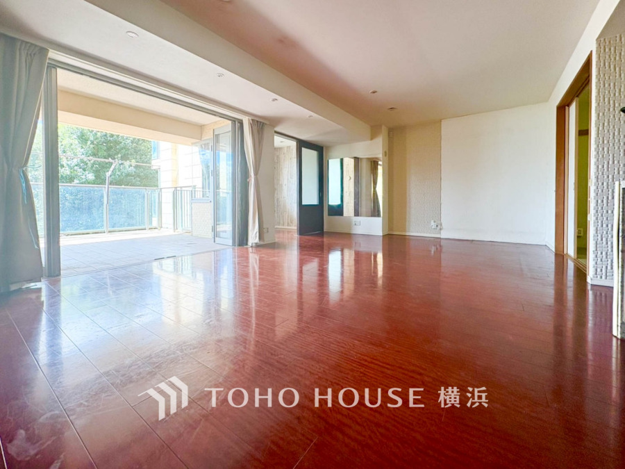 陽光が差し込む広々としたリビング。大きな窓からバルコニーへ続き、開放感あふれる空間です。