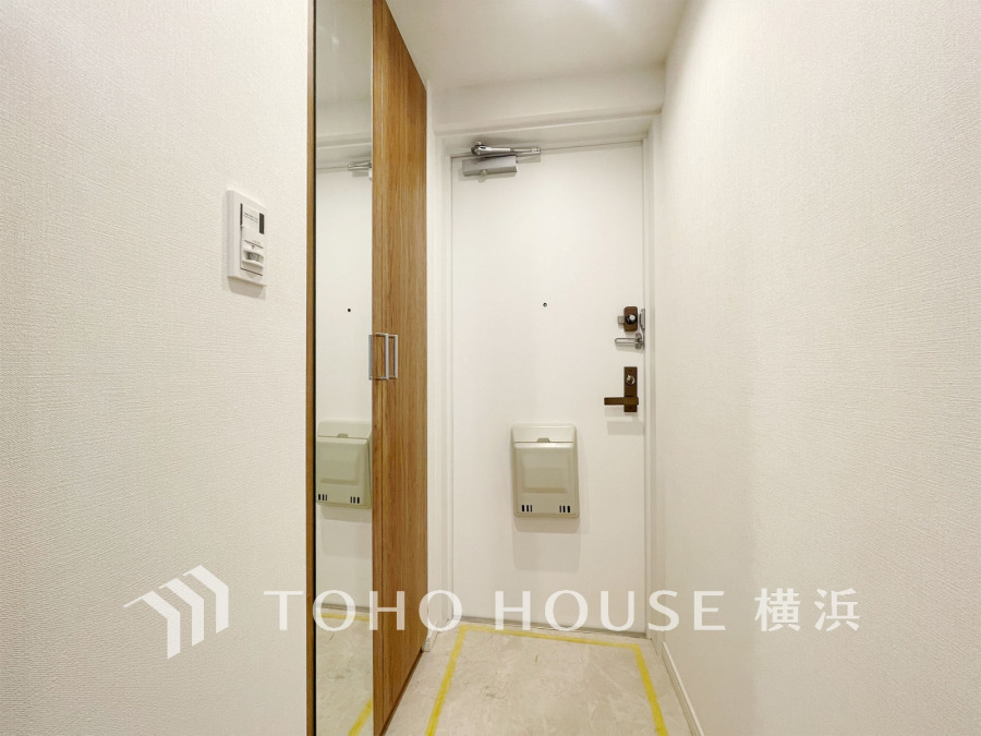 豊富な収納を確保した玄関スペース。便利な大型のミラーのついたシューズボックスを設置。
