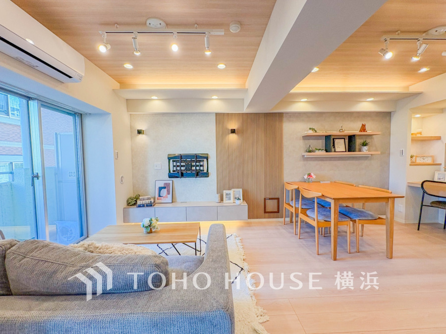 木目天井と間接照明が温かみを演出する、開放感あふれるリビングダイニング空間です。