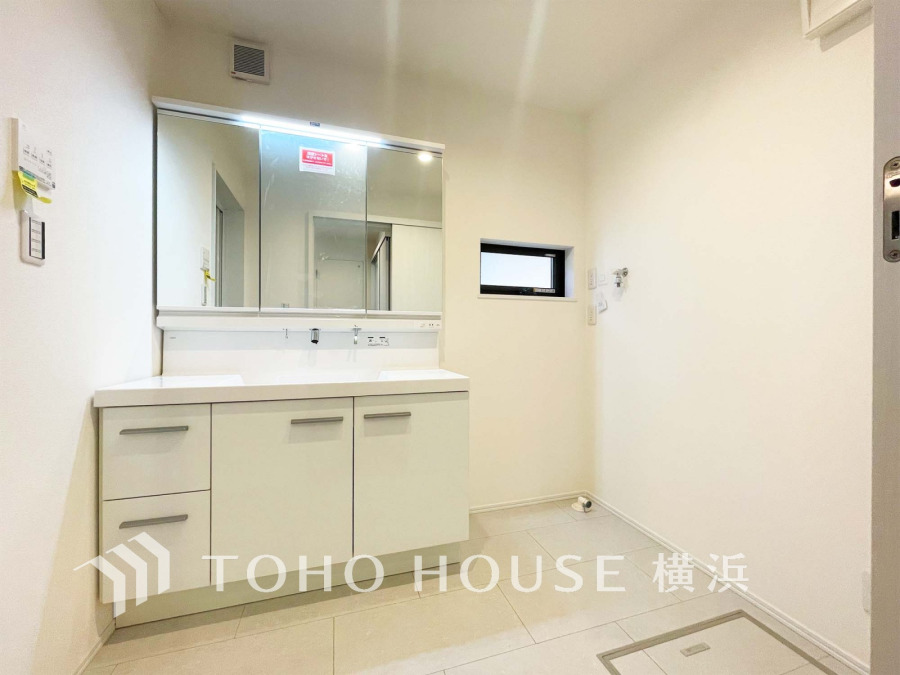 白を基調とした清潔感ある洗面所。大きな鏡と収納で使い勝手も良く、明るく快適な空間です。