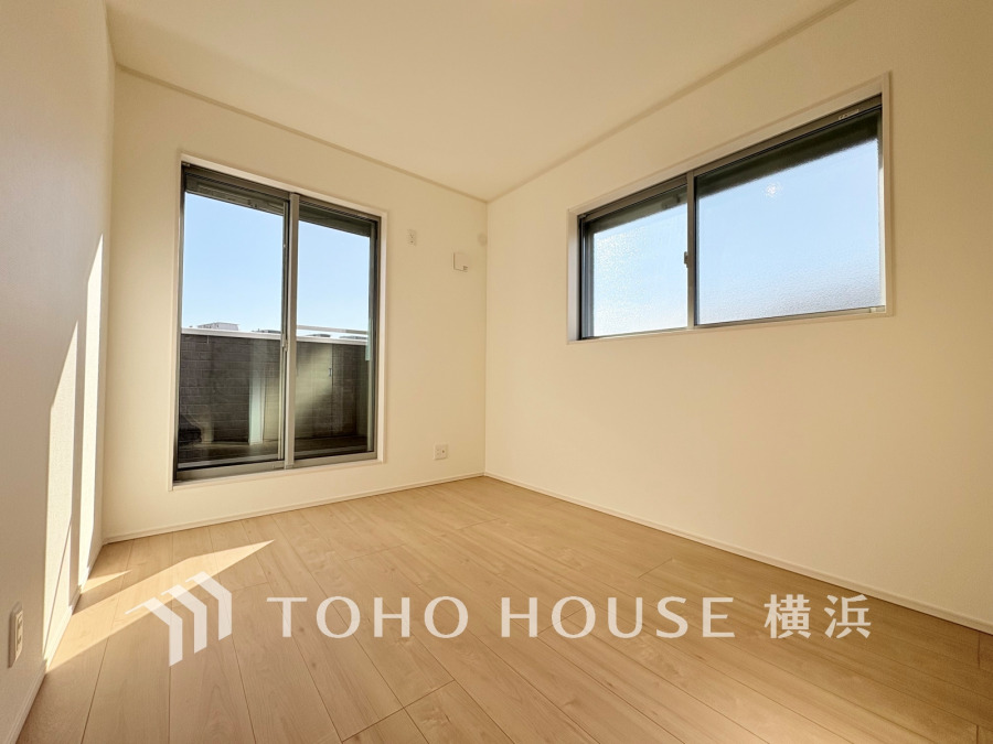 明るい光が差し込む、シンプルで清潔感のある居室。バルコニーに面した大きな窓が開放感を演出します。