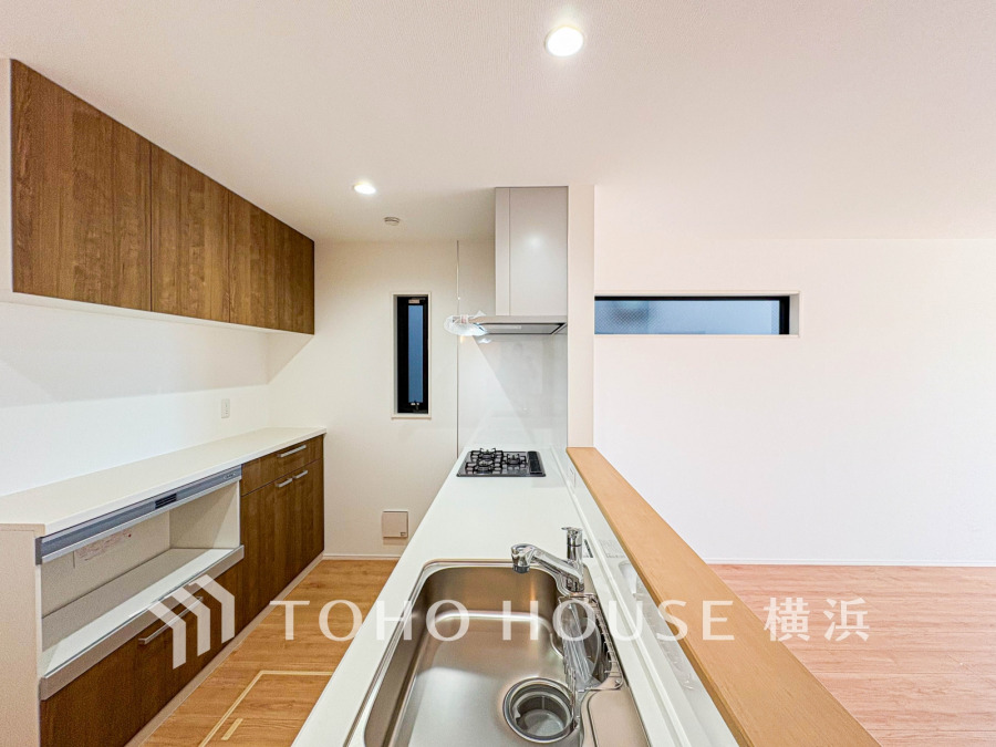 木目調の収納と白を基調とした清潔感あるキッチン。対面カウンターで家族との会話も弾みます。