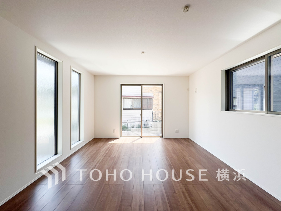 3面に窓を設けた明るく開放的なリビング。木目調フローリングが温かみを演出しています。