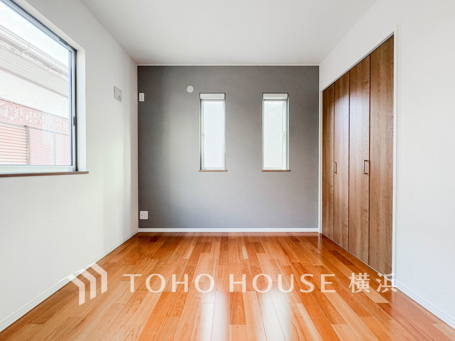 温かみのある木目調フローリングとアクセントクロスが調和した、明るく開放的な洋室です。収納も充実しています。