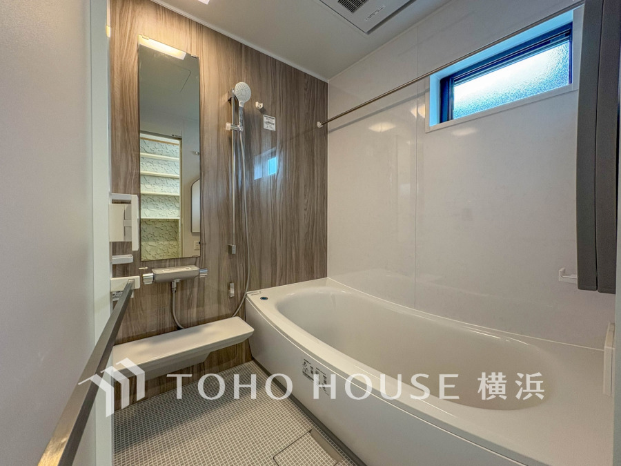 木目調パネルが温かみを演出する、清潔感あふれるシンプルなバスルーム。窓から自然光も取り込めます。