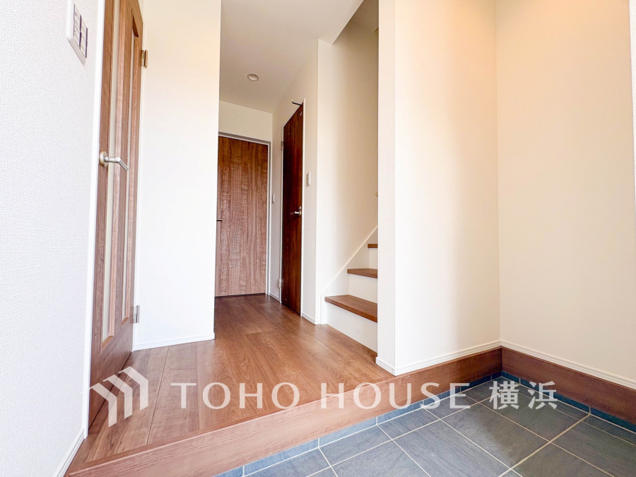 明るく清潔感のある玄関ホール。玄関タイルと木目調フローリングの調和が美しく、収納や階段への動線もスムーズです。