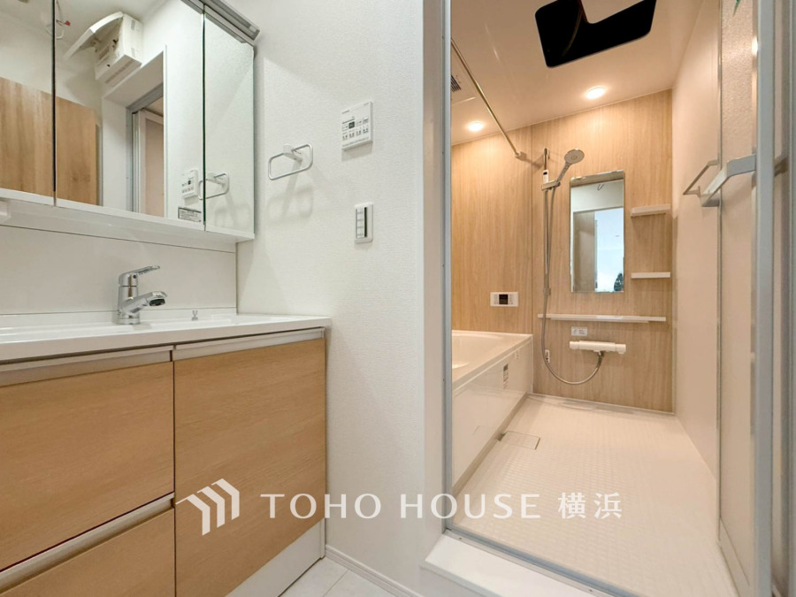 木目調の壁が温かみを演出する洗面所とバスルーム。清潔感あふれる快適な空間です。