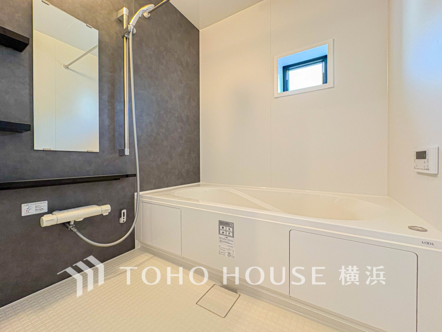 シンプルで清潔感のあるバスルーム。窓から自然光が入り、快適な入浴時間を演出します。