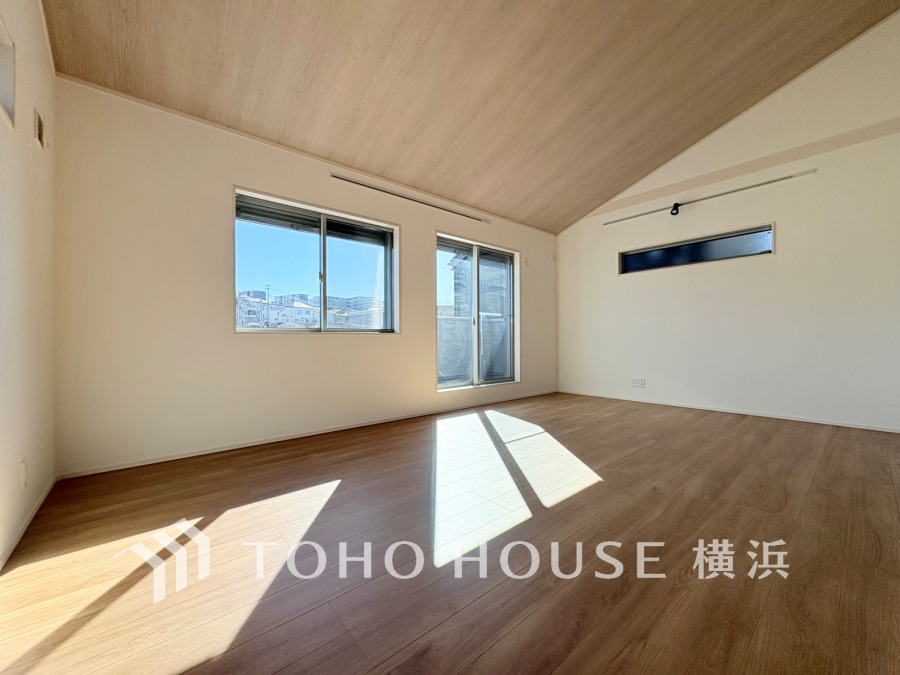 陽光が差し込む開放的なリビング。木目調の天井と床が温かみを演出し、快適な居住空間を実現しています。