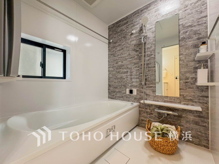 落ち着いたグレーの壁面がアクセントの清潔感あるバスルーム。