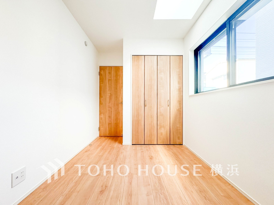 明るい自然光が差し込むシンプルで清潔感のある洋室。収納充実で使い勝手も良好です。