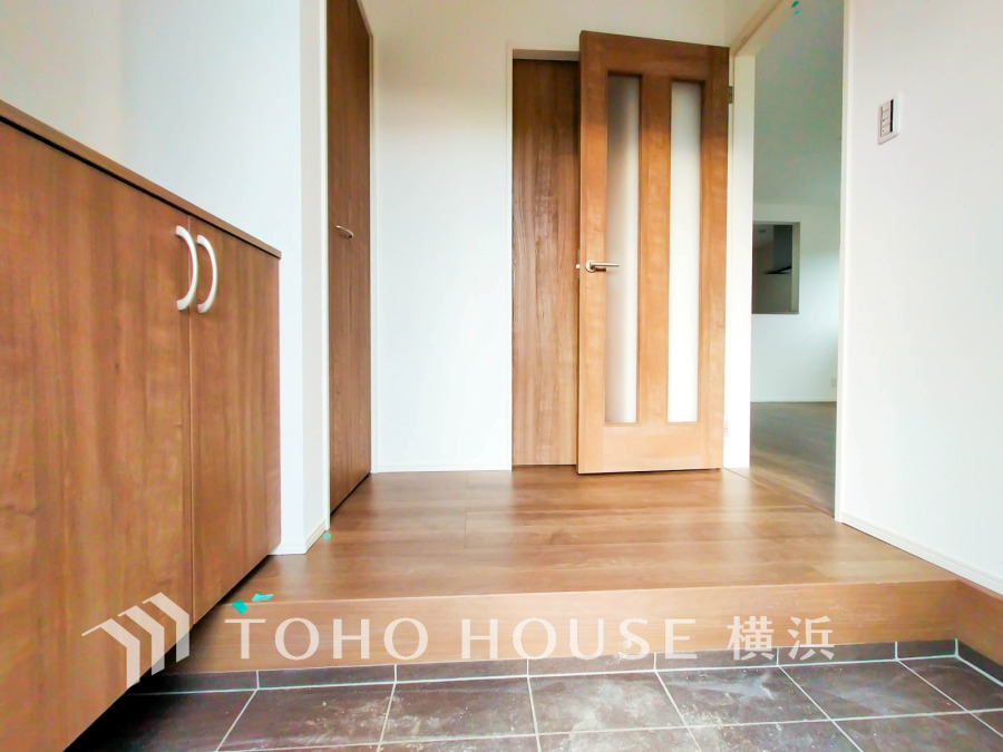 木目調の収納とフローリングが調和した明るい玄関。広々とした空間で快適な出入りが可能です。