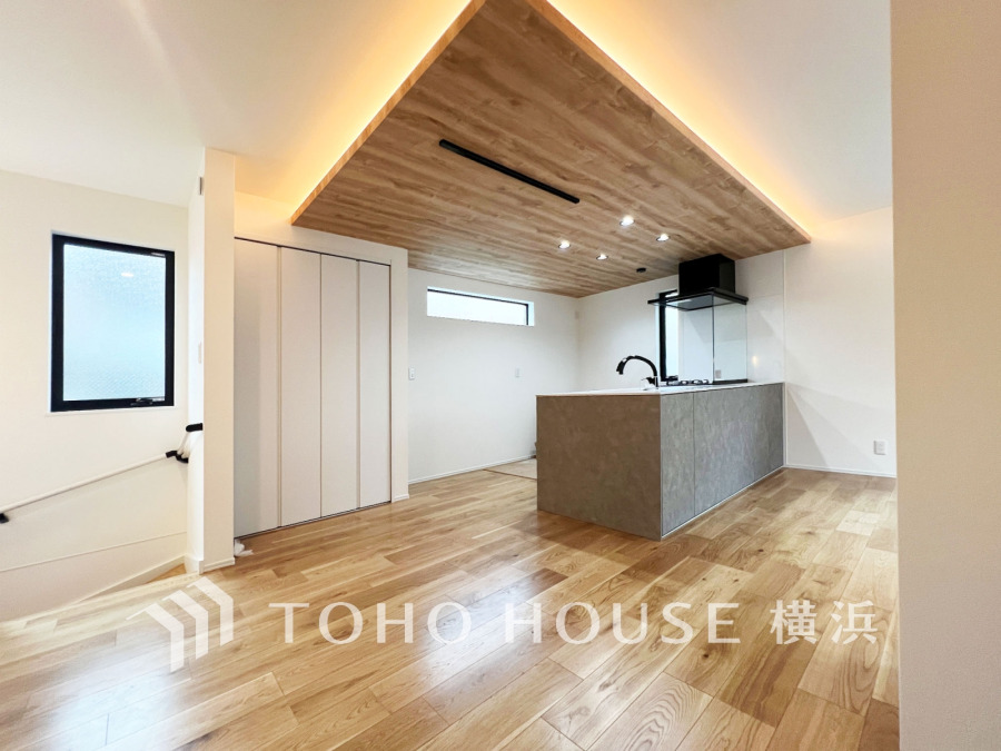 木目天井と間接照明が温かみを演出する、開放感あふれるキッチンスペースです。