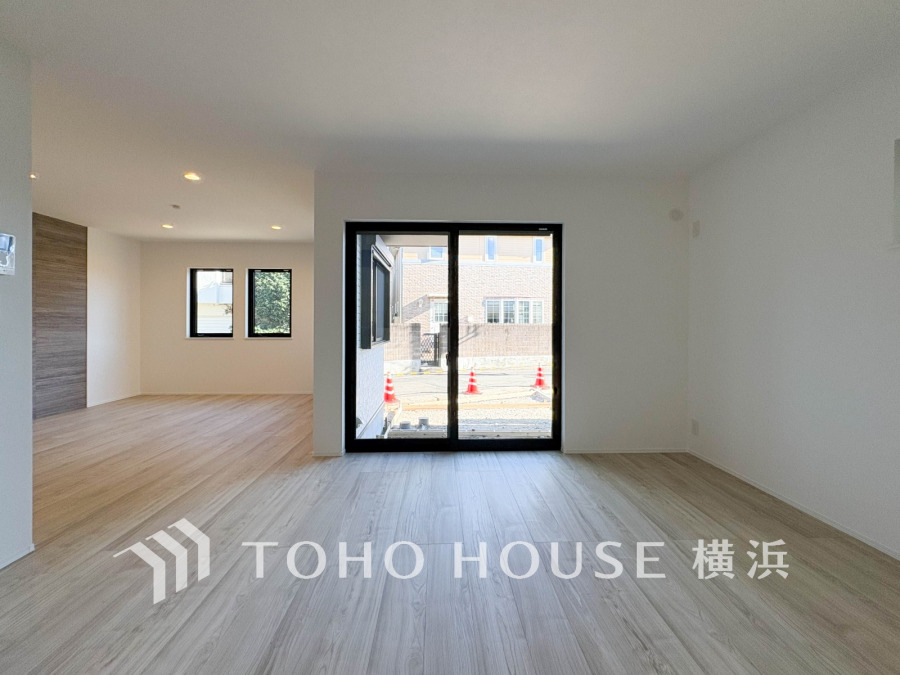 陽光が降り注ぐ広々としたリビングは、家族の笑顔が集まる中心です。木目調のアクセントウォールが洗練された空間を演出し、毎日を豊かに彩ります。