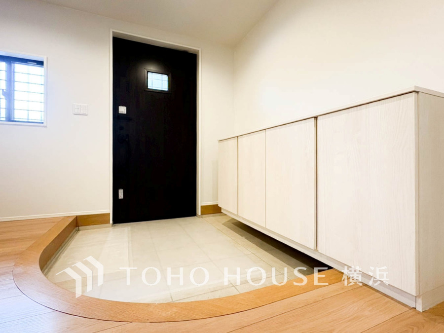 ゆったりとした玄関スペース。明るい木目調の収納でスッキリ整理でき、来客時も爽やかな印象を与えます。