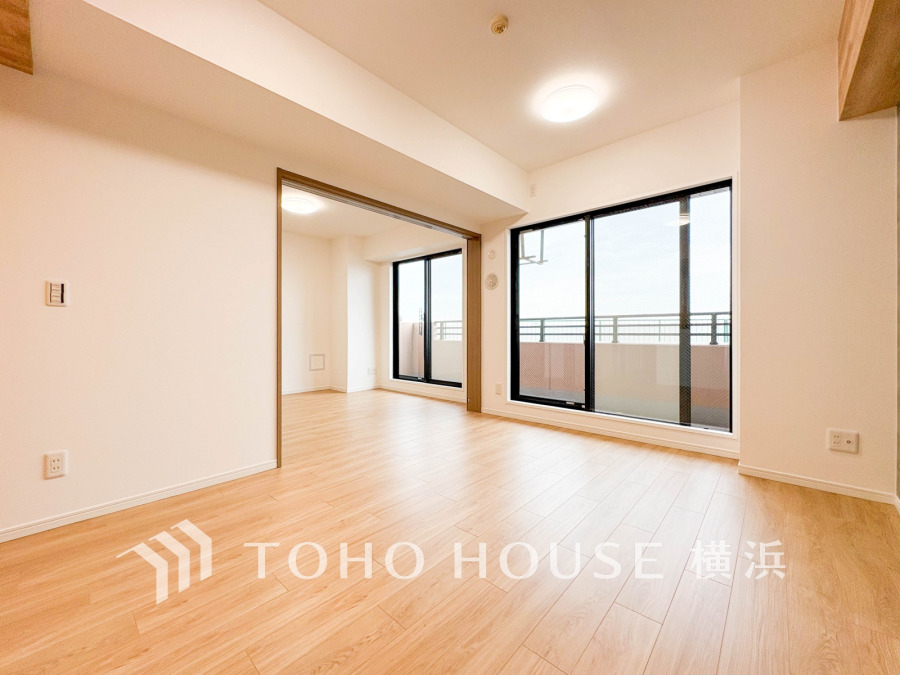 明るい自然光が差し込む広々としたリビング。バルコニーに面し、開放感あふれる快適な空間です。