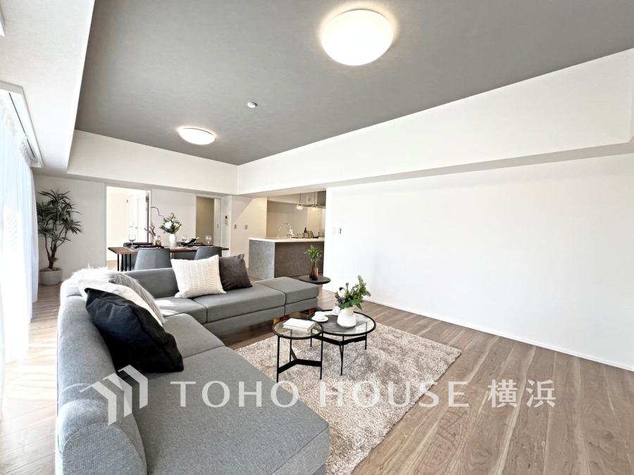 明るい自然光が差し込む広々としたリビング。落ち着いたグレーの天井が空間にアクセントを添えます。