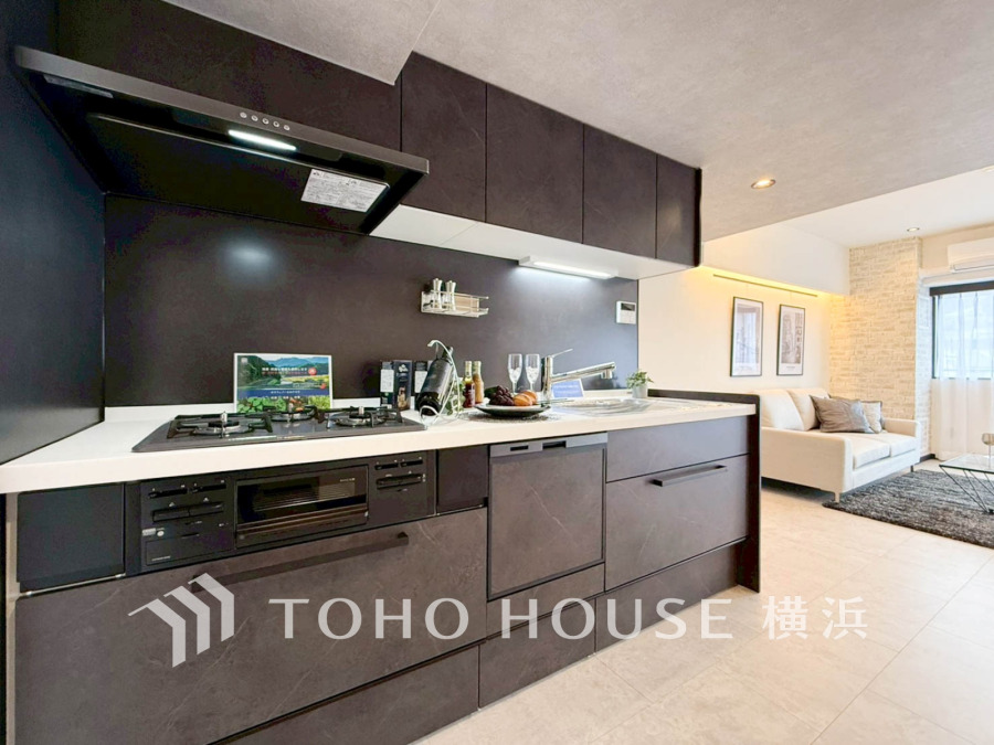 落ち着いたダークカラーのキッチンは、リビングと一体感があり開放的で使い勝手も良いデザインです。