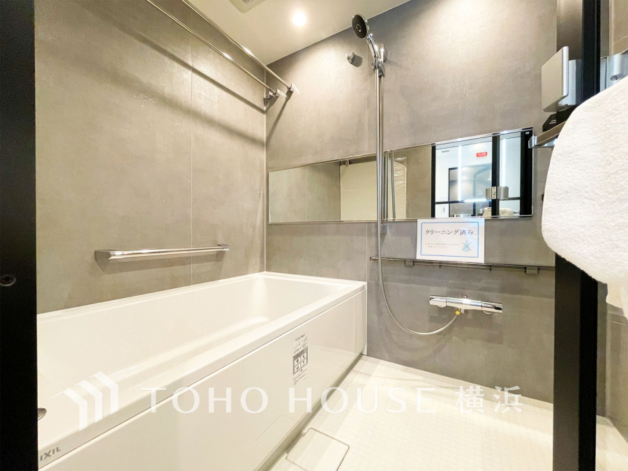 スタイリッシュなグレーの壁と広々とした浴槽でリラックスできる、清潔感あふれるバスルームです。