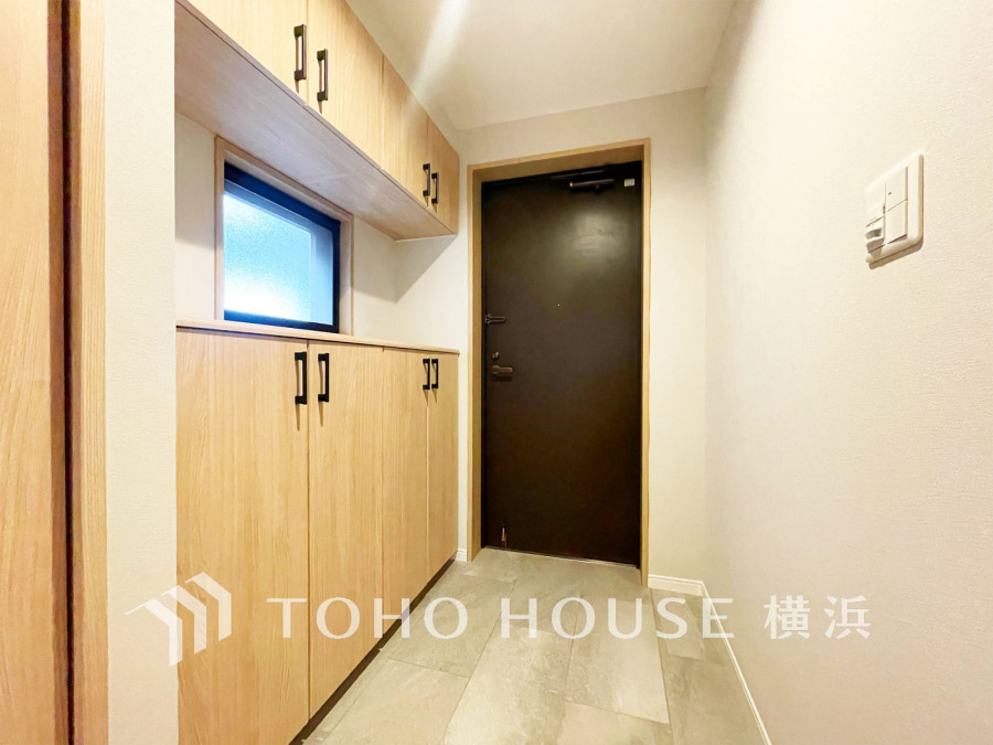 ナチュラルな木目調の収納が備わる、明るい玄関スペースです。